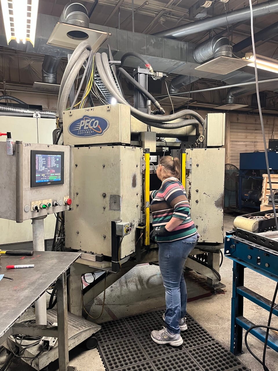A PECo employee operating production equipment on the shop floor